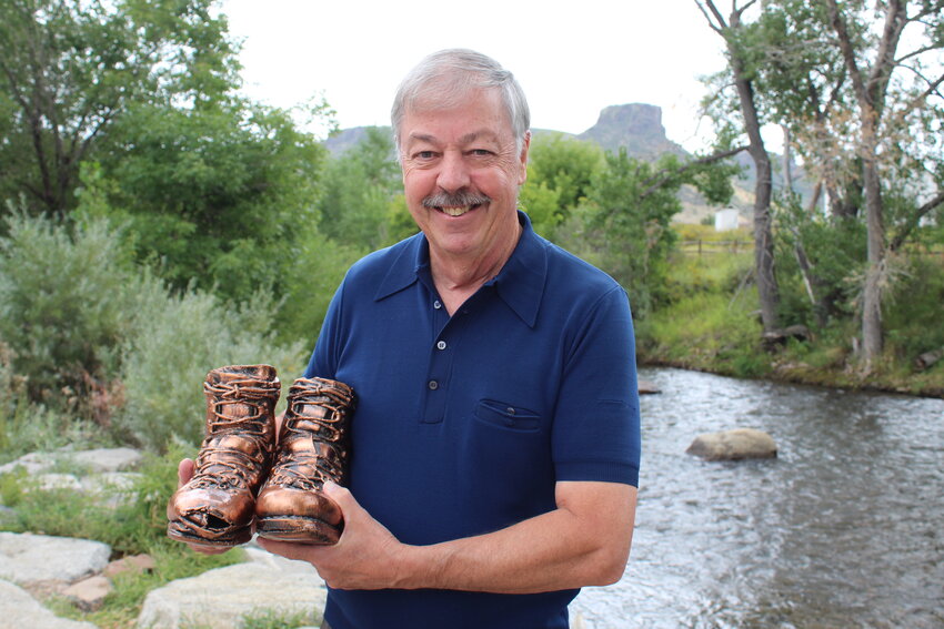Golden resident Jim Closs holds up the boots he used to climb all of Colorado's 14ers and other iconic peaks from 1977-1981. He had the boots bronzed in the mid-1980s and has considered lending them to a museum for public display.